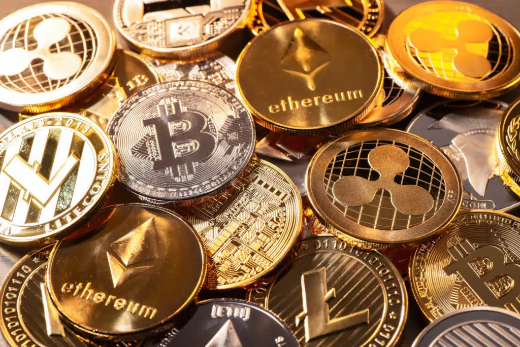 Pièces de cryptomonnaies comme Bitcoin, Ethereum et Ripple symbolisant l’investissement digital des entreprises