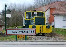 Locomotive jaune et verte en exposition à l’entrée de la commune de Les Avenières, près d’un panneau routier D40 – symbole local représentatif du patrimoine, dans l’environnement de votre expert-comptable Les Avenières.