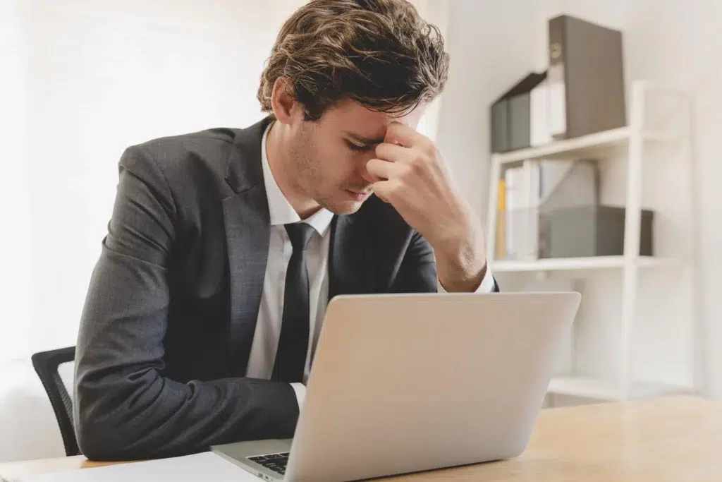 Entrepreneur stressé devant son ordinateur après une radiation d’office du RCS