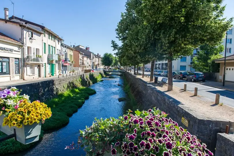 Vue du centre de Montluel avec la rivière et les quais arborés, dans l’Ain (01120), proche des entreprises locales.