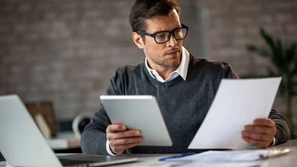 Entrepreneur consultant un formulaire ACRE 2026 et des documents Urssaf pour une demande d’exonération de cotisations sociales